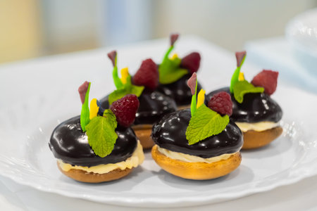 Assortment of delicious fresh shortcrust tart cakes with cream, chocolate and fruits on white plate...