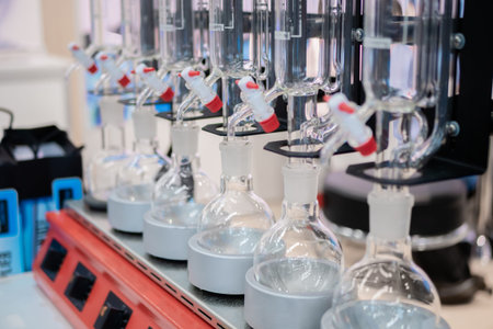 Laboratory equipment - empty glass flask on heating mantle in row. Chemistry, science,...