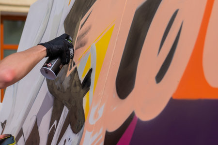 MOSCOW, RUSSIA - APRIL 5, 2019: Summer Graffiti Festival. Close up side view - man hand spraying paint from spray can on wooden surface. Urban culture, freedom, creativity, street art conceptのeditorial素材