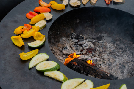 Process of cooking vegetable - bell pepper, zucchini slices on grill at summer outdoor food market - close up. Professional cooking, catering, cookery, barbecue, gastronomy and street food conceptの写真素材