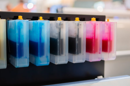 Row of inkjet printer CMYK cartridges - cyan, magenta, yellow, key or black colors - close up view.