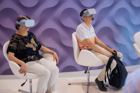 MOSCOW, RUSSIA - JANUARY 5, 2020: Interactive VR exhibition. Young man and elderly woman using virtual reality headsets and looking around. Technology, augmented reality and entertainment conceptのeditorial素材