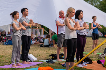 MOSCOW, RUSSIA - MAY 5, 2019: Summer yoga festival. Group of people doing stretching and yoga exercises at forest, park. Fitness, sport, outdoor activity and relaxation conceptのeditorial素材