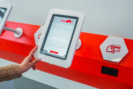 MOSCOW, RUSSIA - JUNE 05, 2019: Technology exhibition. Close up: woman hand using vertical information white tablet kiosk with registration form at classroom, museum with futuristic sci-fi interiorのeditorial素材