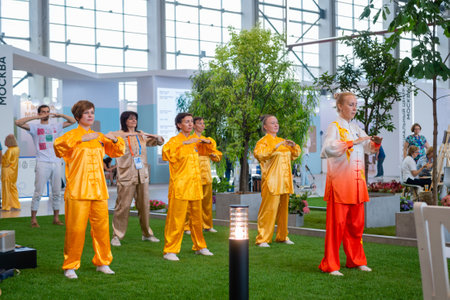 MOSCOW, RUSSIA - JANUARY 5, 2020: Social innovation exhibition. Group of people doing qigong exercise together. Wellness, spiritual, relaxation, praticing, sport, training and martial arts conceptのeditorial素材