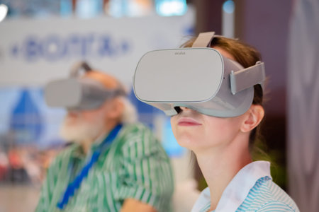 MOSCOW, RUSSIA - JANUARY 5, 2020: VR exhibition. Young woman and elderly man using virtual reality...