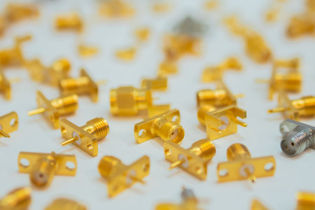 Many golden SMA connectors on white surface at exhibition, trade show - close up, selective focus. Technology, industrial, production and manufacturing conceptの写真素材