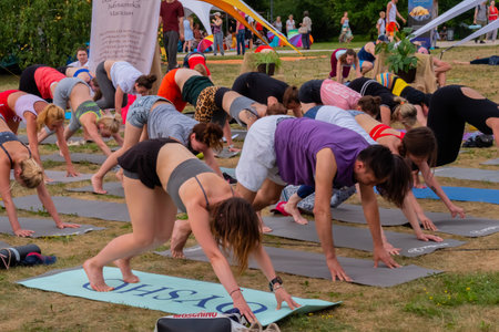 MOSCOW, RUSSIA - MAY 5, 2019: Summer yoga festival. Group of people doing stretching and yoga exercises at forest, park. Fitness, sport, outdoor activity and relaxation conceptのeditorial素材