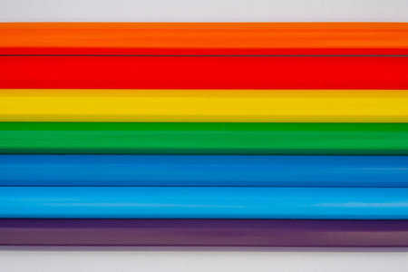 Many different colored pencils on white surface, background - close up, top view. Abstract, creative and education conceptの写真素材