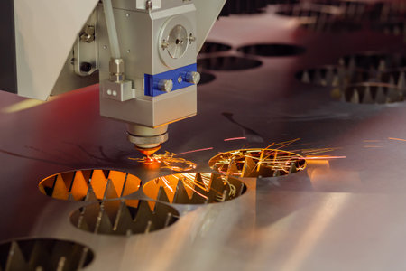 CNC laser cutting machine working with sheet metal with sparks at factory, plant - close up. Metalworking, machining, industrial, equipment, technology and manufacturing conceptの写真素材