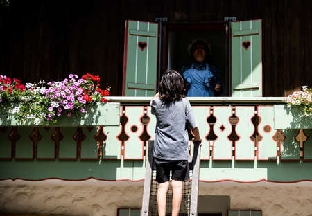Rear view of a man and a woman standing on the stairs in front of an old houseの写真素材