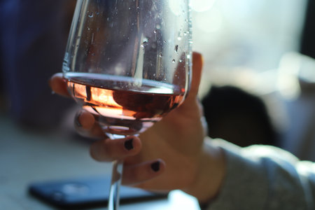 Beautiful woman holding a wine glass. There's rosÃ© wine in the glass.の写真素材