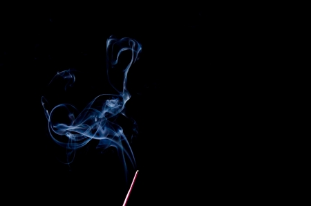 Incense Stick with Smoke on Black Background の写真素材