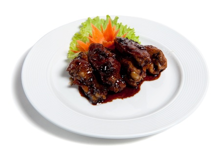 Roast chicken wings on a plate isolated on white backgroundの写真素材