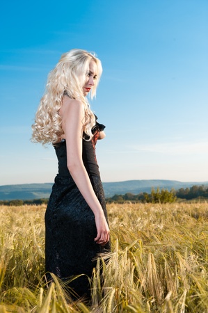 portrait of beautiful girl blonde gothic in wheat fieldの写真素材