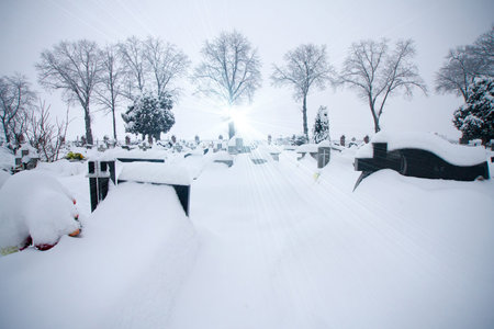 Frozen cementery covered by the snow winter