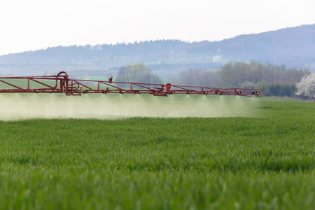 Spraying the herbicides on the green fieldの写真素材