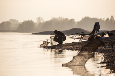 Fisherman at the border of the calm lakeの写真素材