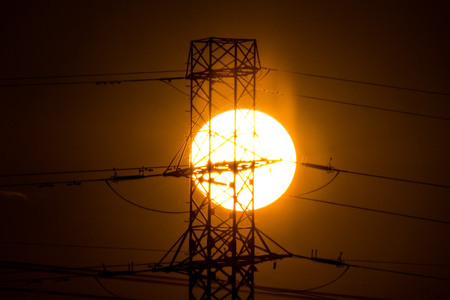 The sunset over the field and the powerlinesの写真素材