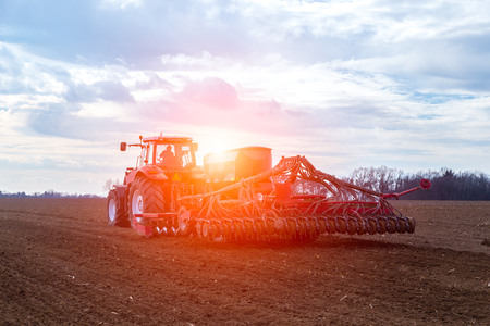 The tractor working on the large fieldの写真素材