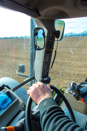 The tractor working on the large fieldの写真素材