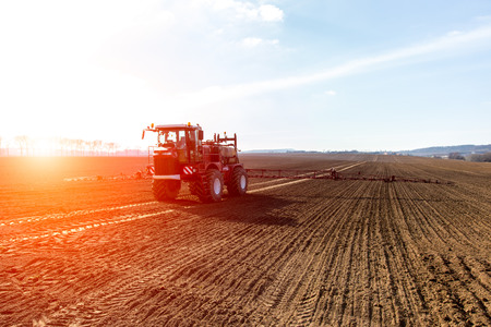 The tractor working on the large fieldの写真素材