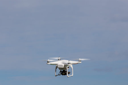Small drone is flying with the blue sky in the background