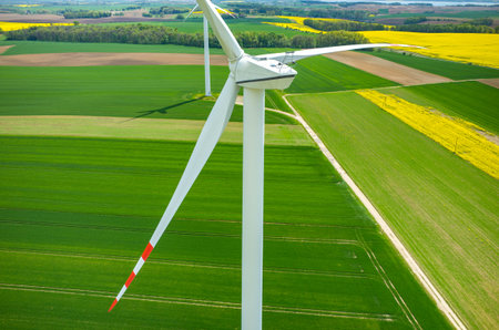 Aerial view on the windmills on the yellow colza field