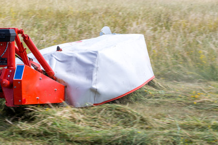 Close view on the mower working on the fieldの写真素材