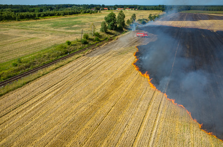 Aerial view on the fireman truck working on the field on fireの写真素材
