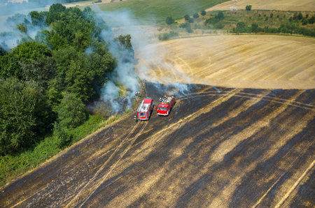 Aerial view on the fireman truck working on the field on fire