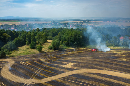 Aerial view on the fireman truck working on the field on fireの写真素材