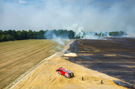 Aerial view on the fireman truck working on the field on fire