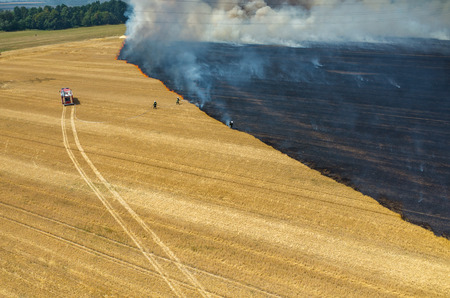 Aerial view on the fireman truck working on the field on fireの写真素材