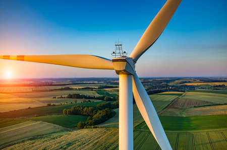 Beautiful sunset above the windmills on the field