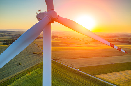 Beautiful sunset above the windmills on the fieldの写真素材