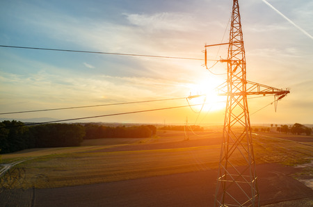Beautiful sunset over the powerlines on the fieldの写真素材