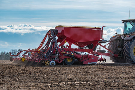 Close view on the tractor harrowing the field in spring season
