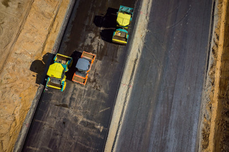 Aerial view on the road rollers working on the new road construction site