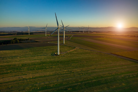Beautiful sunset above the windmills on the field