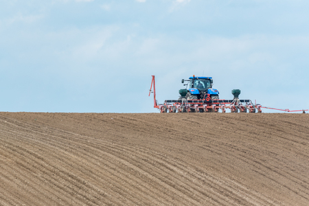 Large view on the tractor harrowing the field in spring seasonの写真素材