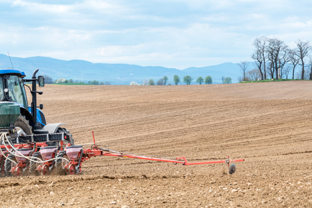 Close view on the tractor harrowing the field in spring seasonの写真素材