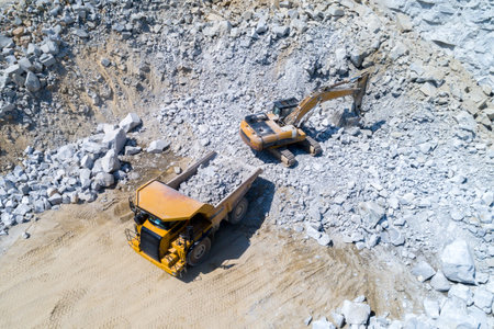 Aerial view on the truck and bulldozer working in the stone mine