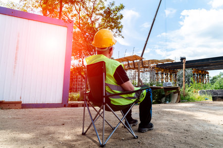 The architect sitting on the chair and watching and controlling the construction site