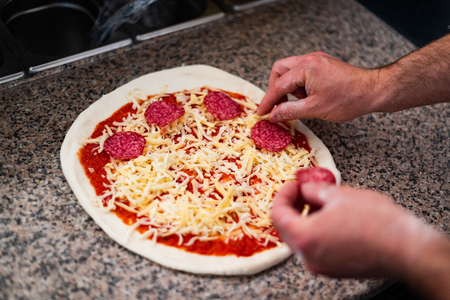 Close view on the cook's hands when he's making the pizzaの写真素材