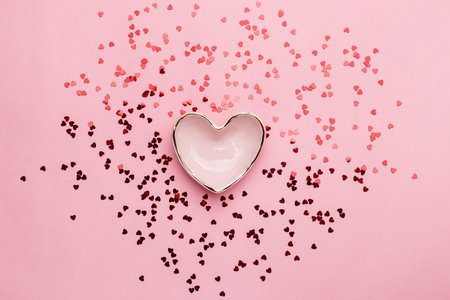 Heart shaped bowl with scattered red confetti