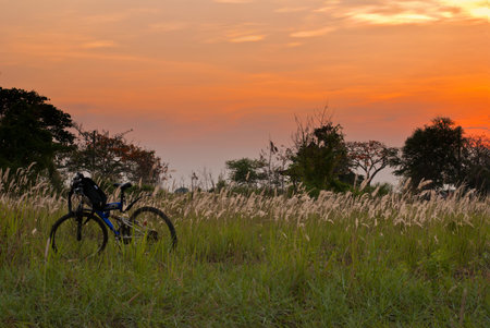 Prairie Sunset with bicycle in grass and beautiful sky and sceneの写真素材