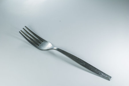 silver spoon and fork in shallow focus close up - isolated on white background