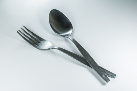 silver spoon and fork in shallow focus close up - isolated on white backgroundの写真素材