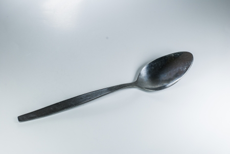 silver spoon and fork in shallow focus close up - isolated on white backgroundの写真素材